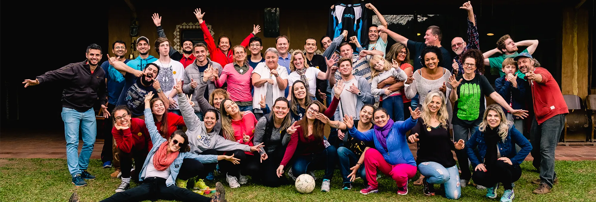 Grupo de participantes do The Fools reunido e sorrindo ao ar livre